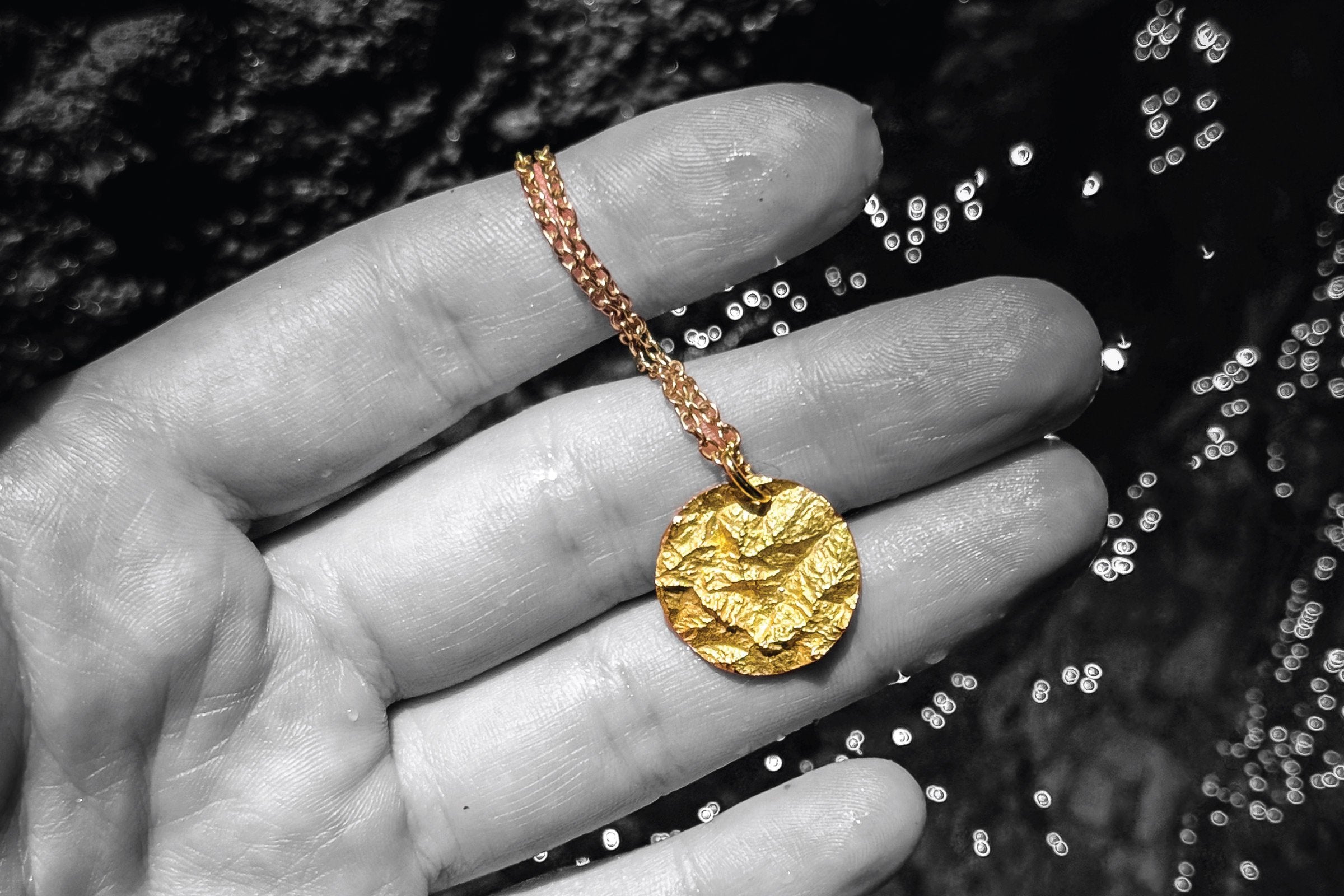 Goldene Bergkette in Handfläche über Wasser – Anfangsberg